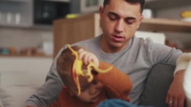 Gülen aile konuşuyor ve evdeki kanepede oturuyor.