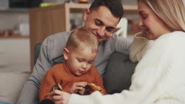 Θετική Οικογένεια Μιλάει Και Κάθεται Στον Καναπέ Στο Σπίτι — Αρχείο Βίντεο