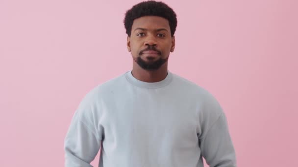 Serieuze Afrikaanse Man Draagt Sweatshirt Praten Iets Roze Studio — Stockvideo