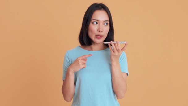 Mulher Concentrada Camiseta Azul Gravando Uma Mensagem Telefone Estúdio Bege — Vídeo de Stock