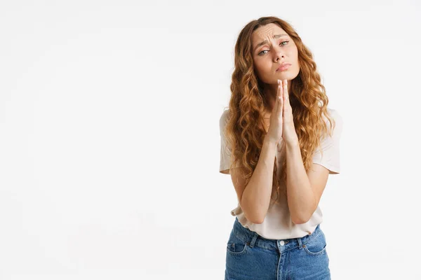 Tişörtlü Genç Kızıl Kadın Beyaz Duvarın Üzerinde Dua Ederken Kaşlarını — Stok fotoğraf