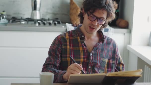 Skoncentrowany Dorosły Mężczyzna Koszuli Kratę Maluje Coś Notatniku Rano — Wideo stockowe