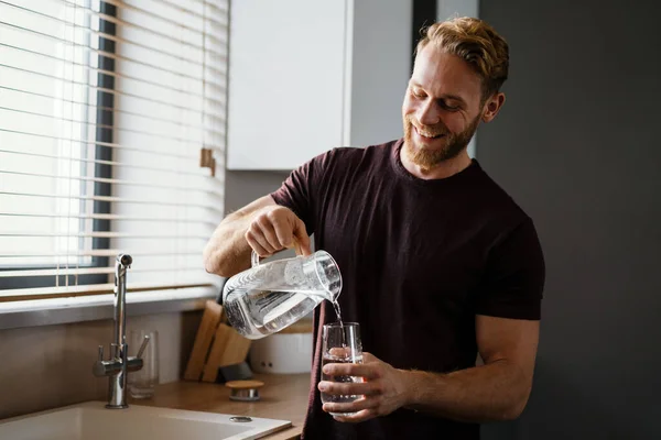 Jeune Homme Attrayant Versant Eau Juf Dans Verre Tout Tenant — Photo