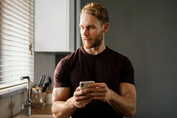 Joven Guapo Usando Teléfono Móvil Cocina — Foto de Stock