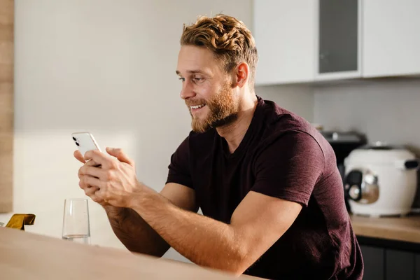 Joven Guapo Usando Teléfono Móvil Cocina — Foto de Stock