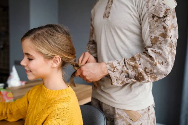 Mužský Voják Dělá Vlasy Své Usměvavé Dceři Doma — Stock fotografie