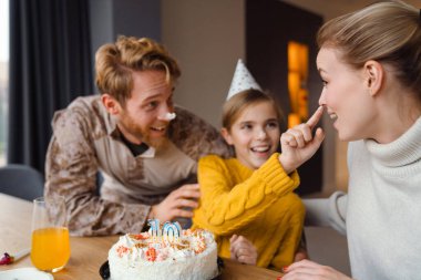 Güzel mutlu bir aile, kızının doğum gününü evde kutluyor.