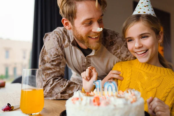 Güzel, neşeli beyaz bir aile, kızının doğum gününü evde kutluyor.