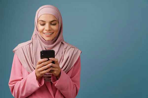 Молода Мусульманка Хіджабі Посміхається Під Час Використання Мобільного Телефону Ізольовано — стокове фото