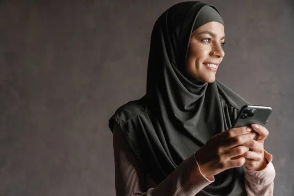 Junge Muslimische Frau Hidschab Lächelt Während Sie Ihr Handy Isoliert — Stockfoto