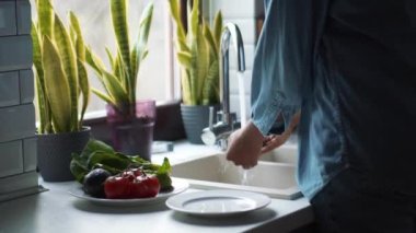 Lavaboda avokado yıkayan kadın elleri.