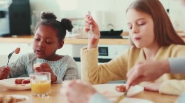 Yakışıklı çokuluslu kardeşler kahvaltılarını evde yapıyorlar.