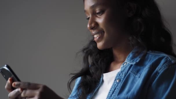 Gelukkig Afrikaans Vrouw Typen Door Telefoon Thuis — Stockvideo