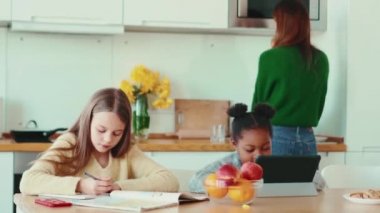 Konsantre olmuş çokuluslu aile mutfaktaki işlerini yapıyorlar.