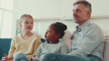 Mutlu yetişkin baba evde çok uluslu kızlarıyla konuşuyor.