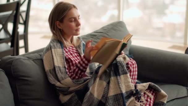 Pensive Ξανθιά Γυναίκα Ανάγνωση Του Βιβλίου Στο Σπίτι — Αρχείο Βίντεο