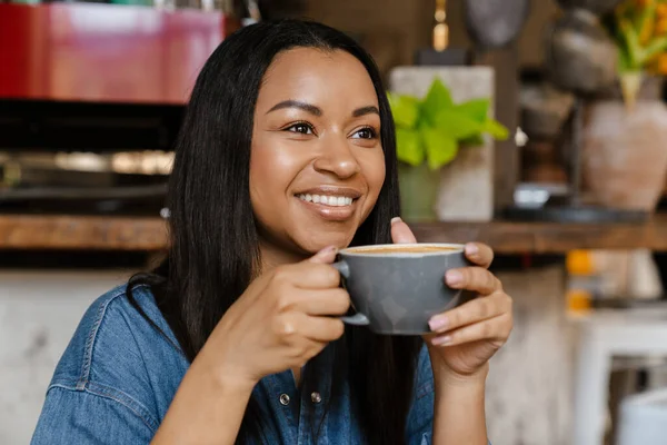 特写一位美丽的非洲裔美国妇女 在室内喝咖啡时面带微笑 — 图库照片