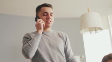 Evde telefonla konuşan olumlu bir baba.