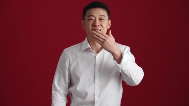 Beyaz Gömlekli Gülümseyen Asyalı Adam Kırmızı Stüdyoda Kameraya Hava Öpücüğü — Stok video