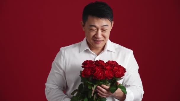 Sorridente Uomo Asiatico Camicia Bianca Tiene Fuori Mazzo Rose Rosse — Video Stock