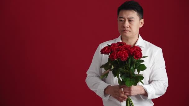 Smutny Azjata Białej Koszuli Bukietem Czerwonych Róż Czeka Kogoś Czerwonym — Wideo stockowe