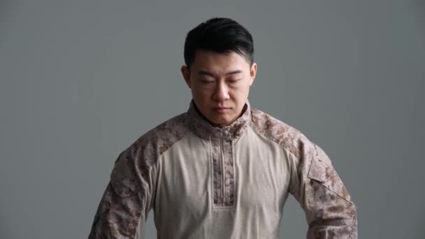 Enojado Soldado Asiático Hombre Cogido Mano Mirando Cámara Estudio Gris — Vídeos de Stock