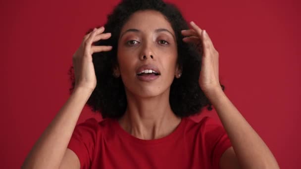 Knappe Afrikaanse Vrouw Corrigeren Haar Kapsel Camera Rode Studio — Stockvideo