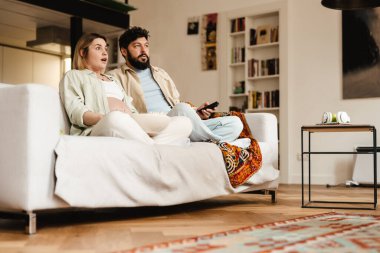 Beyaz çift film izlerken ve evde kanepede otururken şaşkınlıklarını dile getiriyorlar.