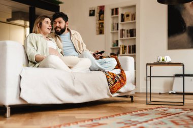 Beyaz çift film izlerken ve evde kanepede otururken şaşkınlıklarını dile getiriyorlar.