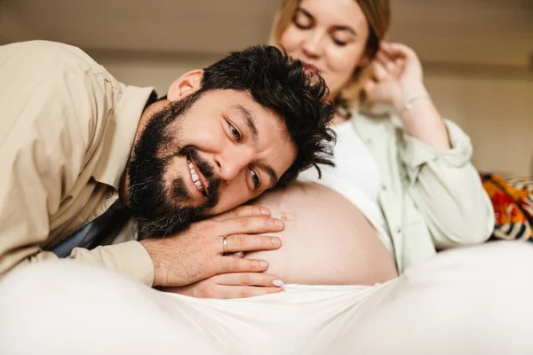 Weißer Mann Lauscht Dem Bauch Seiner Schwangeren Frau Während Hause — Stockfoto