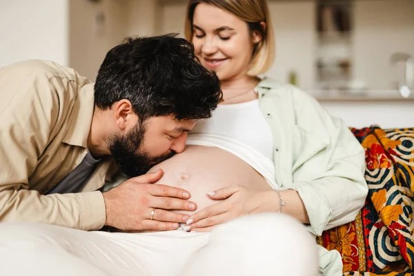 Blanke Man Zoenen Zijn Zwangere Vrouw Buik Terwijl Zitten Bank — Stockfoto