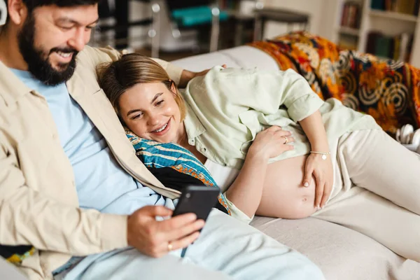 Baard Man Zwangere Vrouw Met Behulp Van Mobiele Telefoon Tijdens — Stockfoto
