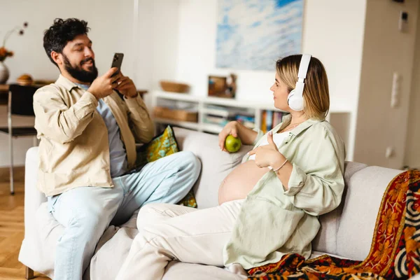 Hombre Blanco Tomando Fotos Esposa Embarazada Mientras Está Sentado Sofá — Foto de Stock