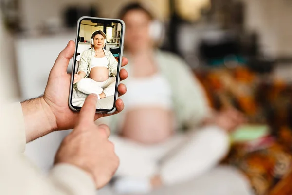 Hombre Blanco Tomando Fotos Esposa Embarazada Mientras Ella Medita Sofá — Foto de Stock