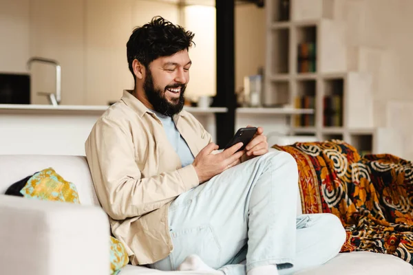 White Bearded Man Laughing Using Cellphone While Sitting Couch Home — Stock Photo, Image