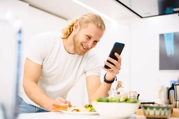 Young White Man Using Cellphone While Having Lunch Kitchen Home — Stock Photo, Image