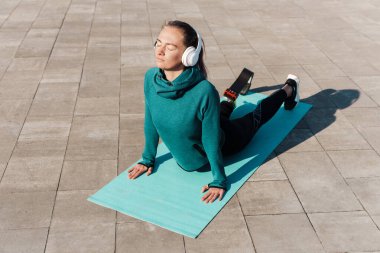 Dışarıda spor yaparken protez takan genç bir sporcu.