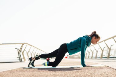 Protezli genç sporcu kadın şehir köprüsünde çalışırken egzersiz yapıyor.