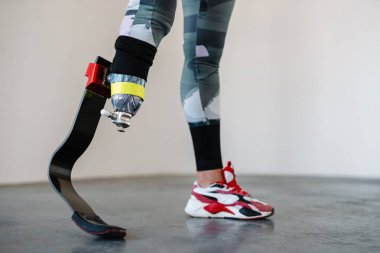 Protezli genç sporcu kadın içeride çalışırken egzersiz yapıyor.