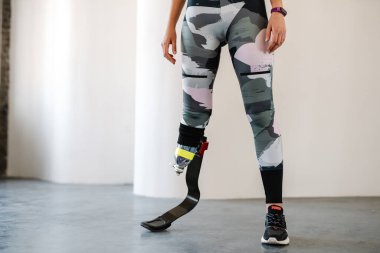 Protezli genç sporcu kadın içeride çalışırken egzersiz yapıyor.