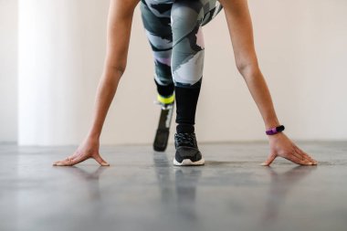 Protezli genç sporcu kadın içeride çalışırken egzersiz yapıyor.