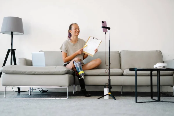 Gülümseyen Engelli Protez Bacaklı Genç Bir Kadın Blogcu Bir Kanepenin — Stok fotoğraf