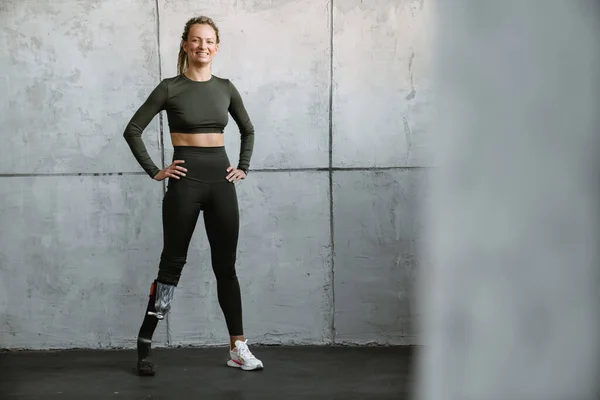 Jonge Sportvrouw Met Prothese Glimlachen Tijdens Het Sporten Binnen — Stockfoto