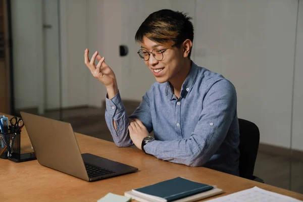 Sorrindo Asiático Cara Óculos Gesticulando Fazer Chamada Vídeo Laptop Escritório — Fotografia de Stock