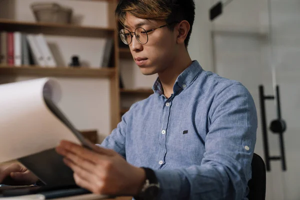 Focado Asiático Cara Óculos Trabalhando Com Papéis Enquanto Sentado Mesa — Fotografia de Stock
