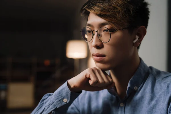 Focused Asian Guy Eyeglasses Using Wireless Earphones While Working Office — Stock Photo, Image