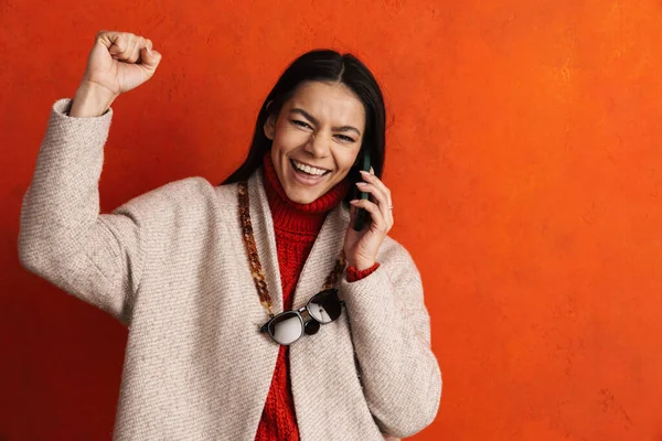 Молода Іспаномовна Жінка Робить Жест Переможця Розмовляючи Мобільному Телефоні Ізольовано — стокове фото