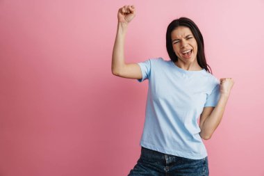 Heyecanlı İspanyol kadın, pembe duvarın üzerinde inzivaya çekilmiş güzel hareketler ve çığlıklar yapıyor.