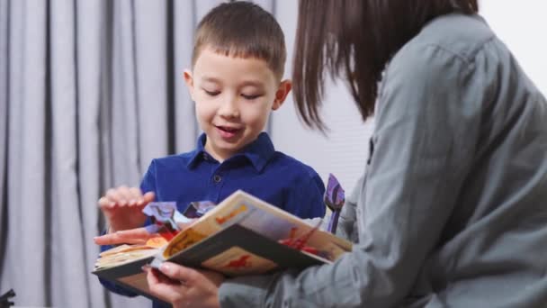 Hermosa Madre Asiática Hijo Mirando Libro Hablando Casa — Vídeos de Stock