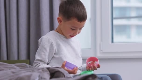 Glad Asiatisk Liten Pojke Leker Med Plast Leksaker Sängen Hemma — Stockvideo